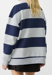 Gestreepte sweatshirt in marineblauw en grijs, met een ontspannen pasvorm en ribgebreide mouwen. Zachte, gestructureerde stof met horizontale strepen.