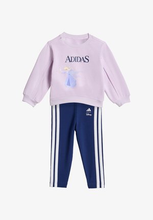 Lilac sweatshirt with "ADIDAS" text and character print, paired with navy pants featuring three white stripes along the sides.