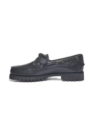 Mocassino nero in pelle con lacci, suola spessa scolpita e occhielli metallici, mostrato di profilo su sfondo bianco.