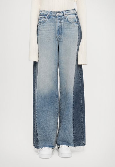 Wide-leg jeans featuring a two-tone design with light blue and dark blue denim. The fabric has a faded texture and frayed hems.