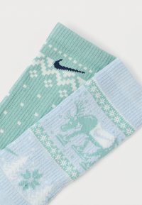 Pletené ponožky s dvoubarevným designem: mátově zelené se sněhovými vločkami a světle modré se vzorem soba. Měkká textura a žebrované manžety.
