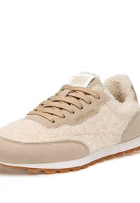 Baskets de sport beige avec une tige en laine texturée, des accents en daim, des lacets en tissu et un logo blanc et or sur la languette. Semelle en caoutchouc avec traction.