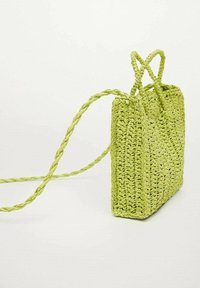 Sac à main vert tressé de forme rectangulaire, avec des poignées tressées et un dessus ouvert. Fabriqué en matériau texturé avec une finition naturelle.