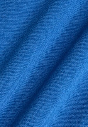 Tela azul con una textura suave y un patrón de punto consistente, que presenta pliegues diagonales que resaltan su flexibilidad y la profundidad de color.