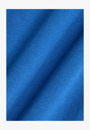 Blue fabric with a smooth texture and a consistent knit pattern, featuring diagonal folds that highlight its pliability and color depth.