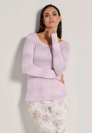 Hellblauer Strickpullover mit langen Ärmeln, der über eine gerippte Textur und ein offenes Maschenmuster verfügt. Kombiniert mit einer Hose im floralen Muster.