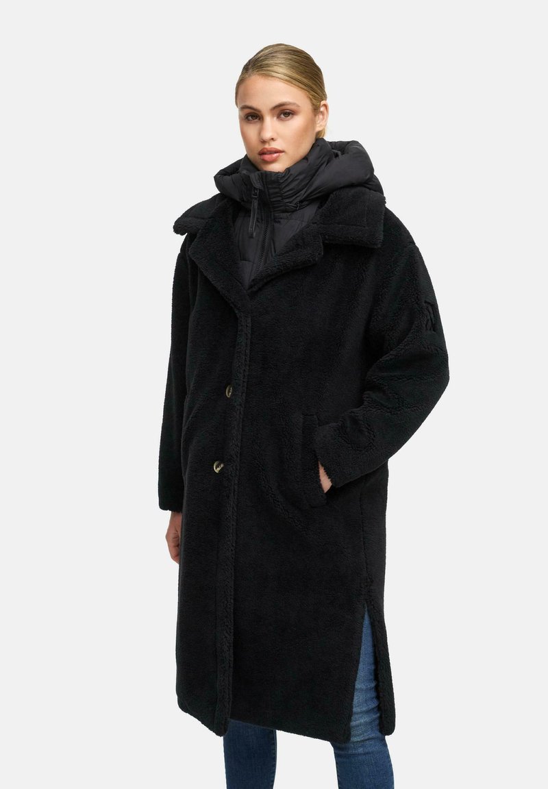 Must must villanehest koos vale karusnahaga, laia kraega, nööbiga kinnise ja küljetaskutega, musta puffer-jaki peal.