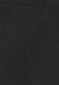 Mörk denimtyg med en mjuk textur; har en klassisk passform och subtil toning av sömmar, vilket betonar en ren, minimalistisk design.