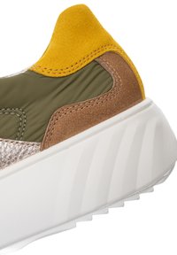 Chunky white sneaker sole with olive green fabric, tan suede, and mustard yellow suede heel accents.