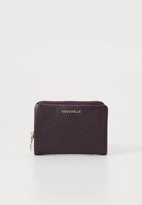 Portafoglio compatto in pelle viola scuro con zip dorata e logo "Coccinelle" impresso in oro al centro davanti.