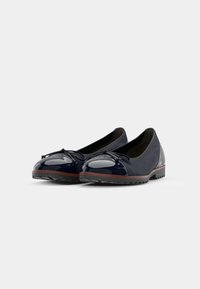 Marineblaue Ballerinas mit glänzendem Lackleder-Zehenkappe und Schleifendetail, ausgestattet mit einem strukturierten grauen Obermaterial und brauner Gummisohle.