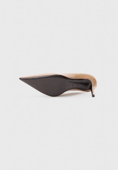 Visoka petka z ostrim prstom iz nude lakiranega usnja s hkrati elegantno obliko in črnim podplatom. Ima petko stileto in gladko teksturo.