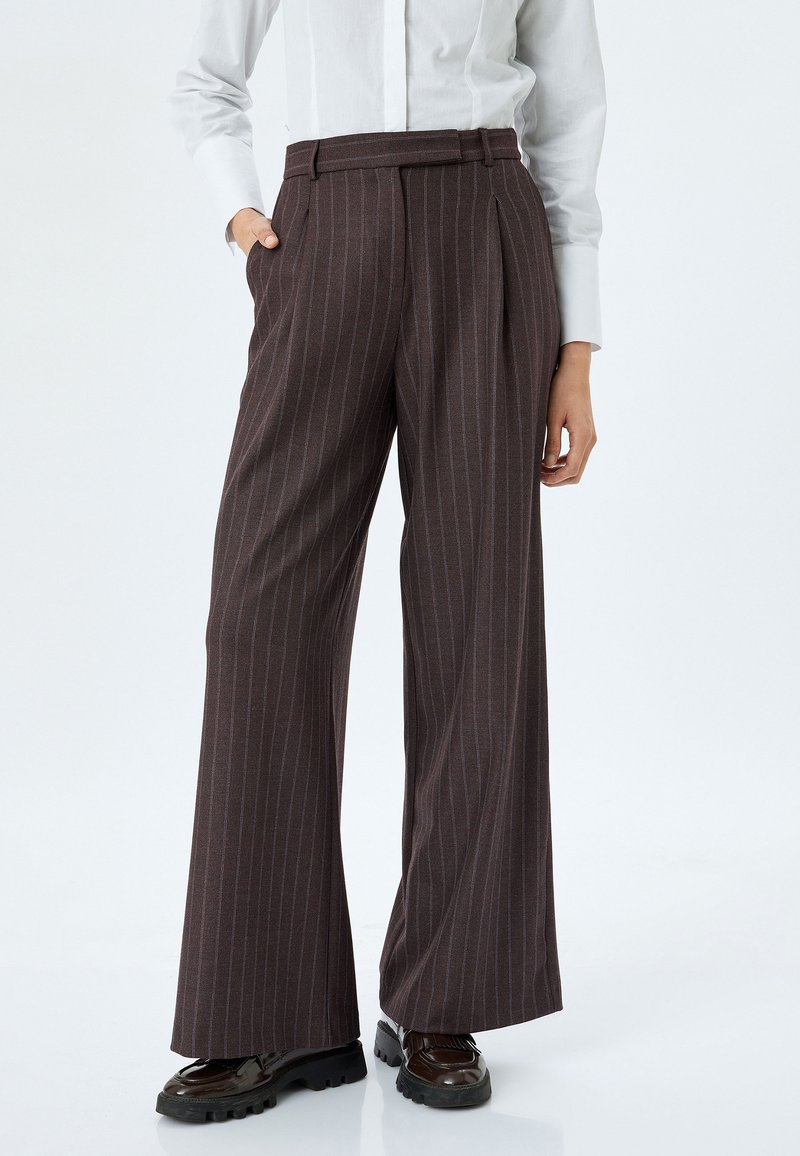 Pantaloni a gamba larga in marrone scuro con righe verticali, caratterizzati da vita alta, pieghe frontali e tasche laterali. Tessuto testurizzato, finitura liscia.