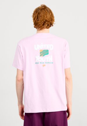 T-shirt in cotone rosa con grafiche sul retro che riportano la scritta "I GIOVANI UNITI SONO IL FUTURO" con un motivo multicolore. Maniche corte.