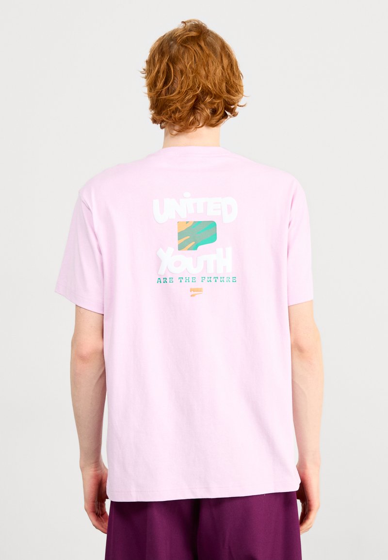 T-shirt in cotone rosa con grafiche sul retro che riportano la scritta "I GIOVANI UNITI SONO IL FUTURO" con un motivo multicolore. Maniche corte.
