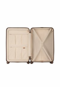 Open beige koffer met ritscompartimenten aan de linkerkant en verstelbare kruisbanden aan de rechterkant, staand op vier wielen.