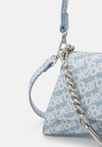 Vaaleansininen kolmionmuotoinen käsilaukku, jossa valkoinen logokuvio, hopeaketjusanka ja irrotettava nahkainen olkahihna.