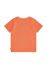 T-shirt a maniche corte di colore arancio corallo, realizzato in cotone testurizzato con colletto a girocollo bianco a coste. Presenta una piccola etichetta gialla sull'orlo.