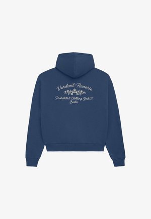 Marineblå hættetrøje med hvid blomsterbroderi og kursiv tekst, der står "Verdant Reverie" og "Prohibited Clothing GmbH Berlin" på ryggen.
