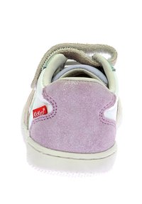 Sneaker per bambini con corpo in pelle bianca, tallone in suede rosa, accenti verdi e strap con velcro. Logo rosso Kickers sul tallone.