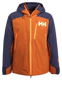Veste orange et marine avec une capuche, dotée de fermetures éclair orange et d'un logo blanc. Tissu texturé avec poignets ajustables et détails de ventilation.