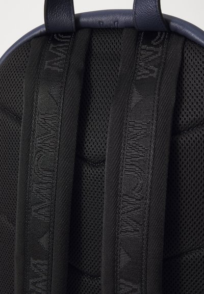 Must have riided mustriga, millel on võrgusilma tekstuur; esitleb logo aktsente ja reguleeritavat pikka; tumesinine sünteetiline nahk ääristab ülevalt.