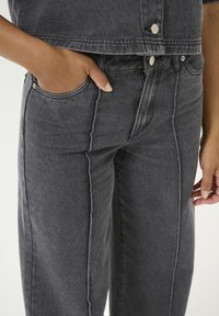 Gray denim pants featuring a fitted waistband, front pocket, and visible seam detailing, with a soft texture and a straight-leg design.