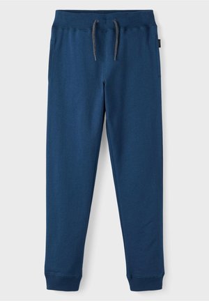 Blaue, zulaufende Jogginghosen mit elastischem Bund, grauem Kordelzug, Seitentaschen und Rippbündchen vor hellem Hintergrund.