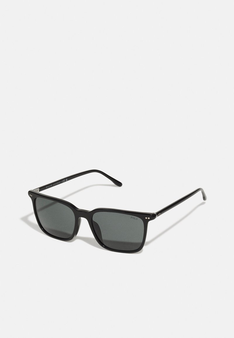 Črne pravokotne sončna očala s sivimi lečami, plastični okvir, srebrni poudarki in detajl logotipa ob strani. Klasičen dizajn z gladko teksturo.