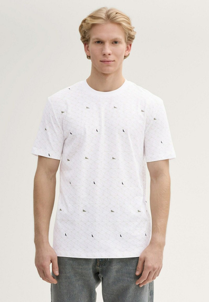 Camiseta blanca de manga corta con un patrón geométrico de formas triangulares en negro y gris, hecha de algodón con una textura suave.