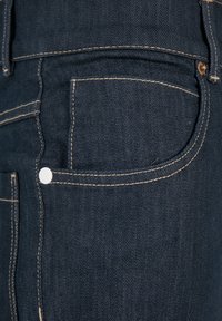 Dark blue denim jeans with contrasting beige stitching, single white button, and a front pocket, featuring a smooth texture.