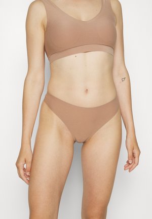 Brown seamless bra and matching briefs made of soft, stretchy fabric. The bra has a deep v-neck; the briefs feature a high-cut leg design.