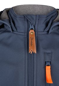 Navy blue jacket featuring a zippered front, leather tag with brand name, and bright orange zipper pull. Soft interior lining visible.