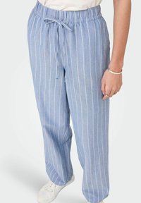 Heledad sinise triibuga püksid, millel on paelaga vöökoht, lõdvestunud lõige ja pehme kangas. Valged vertikaalsed triibud kontrastuvad põhivärviga.