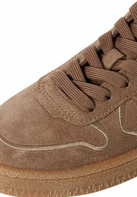 Sneaker in suede marrone con finitura testurizzata, design con lacci e suola in gomma. Presenta cuciture sottili e una punta arrotondata.