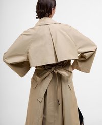 Beige trench coat with wide sleeves, back pleats, and a tied waist. Features side pockets and a smooth, lightweight fabric.