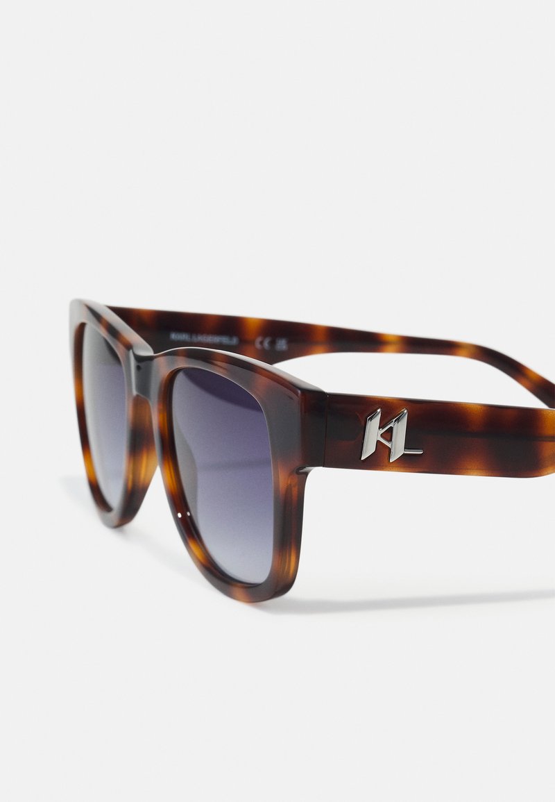 Schildpatt-Sonnenbrille mit dunklen Verlaufslinsen, quadratischen Rahmen und silbernem Akzent am Bügel mit 'KL'-Logo.
