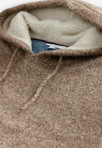 Brun uld hoodie med en blød, cremefarvet fleecefoering, en hætte med snoretræk og et tekstureret strikdesign.