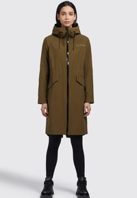 Olivgrön huoodad parka med dragkedja framtill, två framfickor och justerbara dragsko. Slät textur och stilren design.