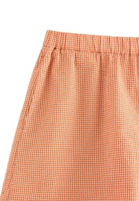 Orange ginghamkjol med elastisk midja, som har ett lätt tyg och en strukturerad yta med växlande små rutor.