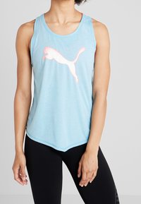 Canotta atletica senza maniche di colore azzurro chiaro con orlo arrotondato, caratterizzata da un grande logo Puma bianco e rosa sulla parte anteriore. Tessuto morbido e traspirante.