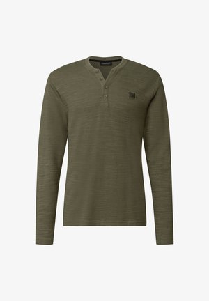 Camicia a maniche lunghe in tessuto verde oliva; presenta un colletto rotondo con tre bottoni, una piccola patch con logo sul petto e una finitura testurizzata.