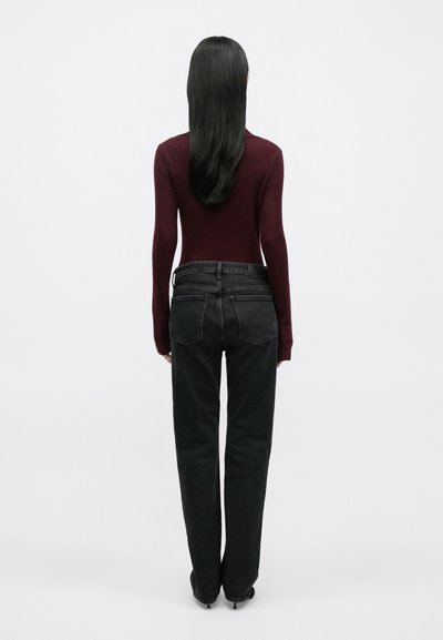 Tmavomodré rifle z denimu s rovnými nohavicami a zadnými vreckami, doplnené o priliehavý bordový top s dlhým rukávom. Hladká textúra, bez viditeľných vzorov.