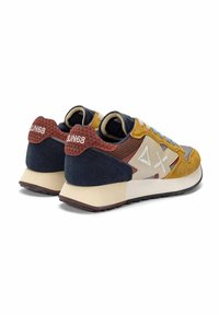 Coppia di sneakers multicolore in suede e tessuto con suole beige, lacci blu e logo "SUN68" sulle linguette del tallone con motivo rosso.