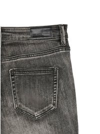 Sección del bolsillo trasero de unos vaqueros de mezclilla negra desgastada con pasador de cinturón y etiqueta de marca de cuero negro "Vero Moda Vero Denim."