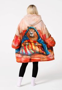 Pārmērīgi liels kapuces sega no mīksta materiāla ar kapibāras dizainu, spilgtām krāsām un rakstainiem segas elementiem.