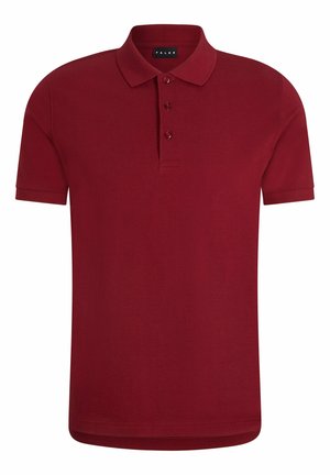 Burgundowa koszulka polo z krótkimi rękawami i kołnierzykiem, z trzema guzikami. Połączona z czarnymi dopasowanymi spodniami i czarnymi sneakersami.