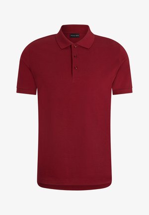 Burgundowa koszulka polo z krótkimi rękawami i kołnierzykiem, z trzema guzikami. Połączona z czarnymi dopasowanymi spodniami i czarnymi sneakersami.