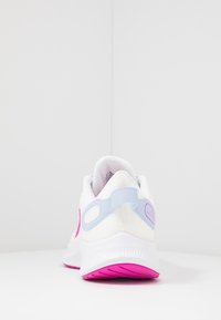 Scarpa sportiva bianca con accenti rosa, tomaia in rete e tallone blu. Presenta una suola con texture per aderenza e ammortizzazione.