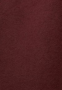 Tissu bordeaux profond avec une texture douce et veloutée, présentant des fibres fines et denses réparties uniformément sur la surface.